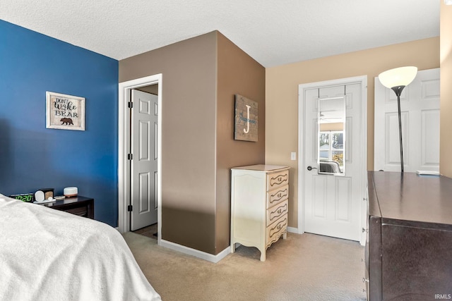 bedroom with baseboards, a textured ceiling, and light colored carpet