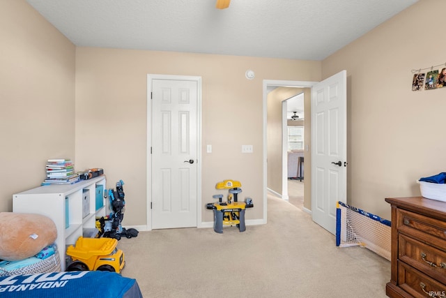 interior space featuring ceiling fan, baseboards, and a textured ceiling