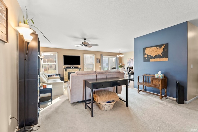 carpeted living room featuring ceiling fan, a textured ceiling, and baseboards