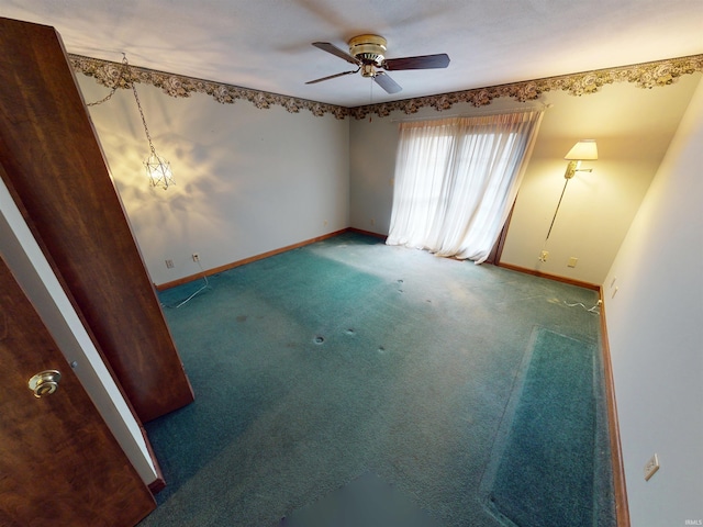 spare room with ceiling fan, carpet, and baseboards