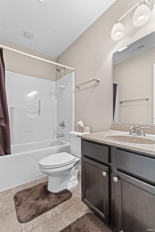 full bathroom featuring shower / bath combination with curtain, visible vents, toilet, a textured ceiling, and vanity