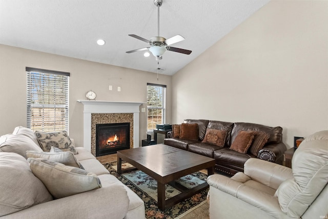 living area featuring a textured ceiling, recessed lighting, a ceiling fan, vaulted ceiling, and a tiled fireplace