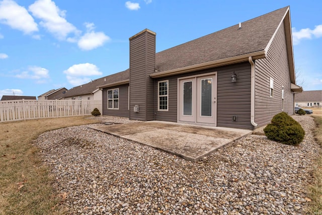 rear view of property with a patio area, fence, a chimney, and roof with shingles