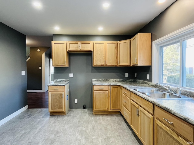 kitchen with recessed lighting, a sink, light wood-style flooring, and baseboards