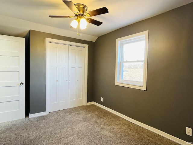 unfurnished bedroom with carpet floors, a closet, a ceiling fan, and baseboards