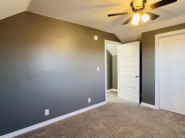 unfurnished bedroom with a ceiling fan, lofted ceiling, carpet, and baseboards