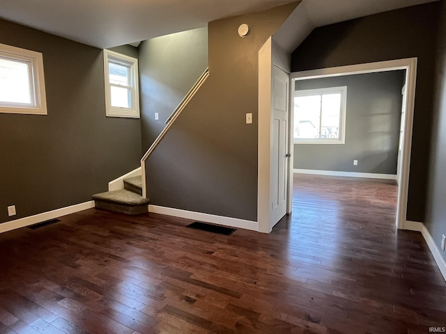 interior space featuring stairway, visible vents, a wealth of natural light, and dark wood-type flooring