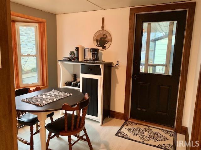 doorway with wood finished floors, baseboards, and a wealth of natural light