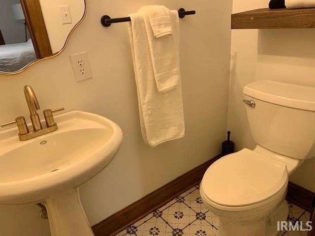 half bathroom with toilet and baseboards