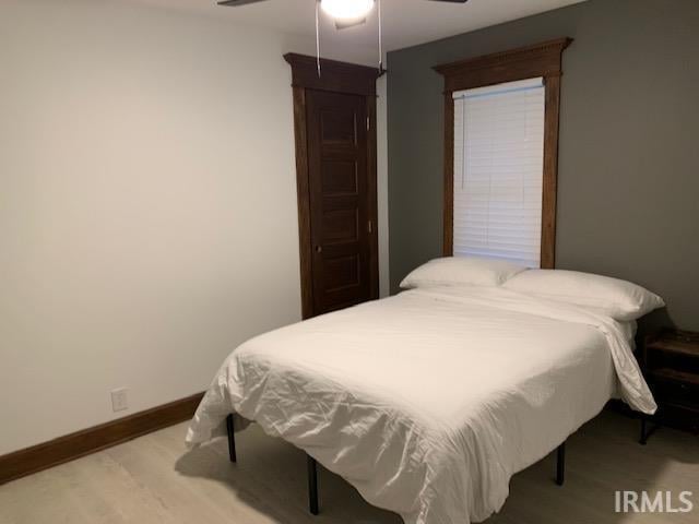 bedroom featuring ceiling fan, baseboards, and wood finished floors