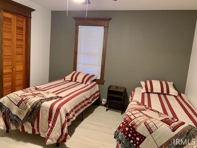 bedroom featuring a closet, a ceiling fan, and wood finished floors