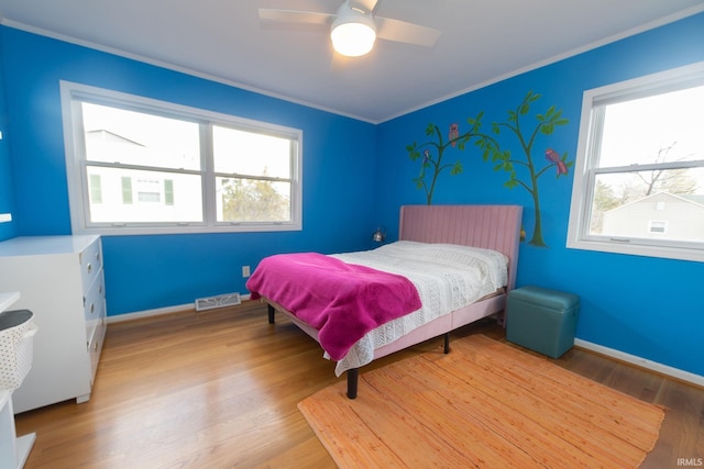 bedroom with light wood-type flooring, visible vents, baseboards, and multiple windows