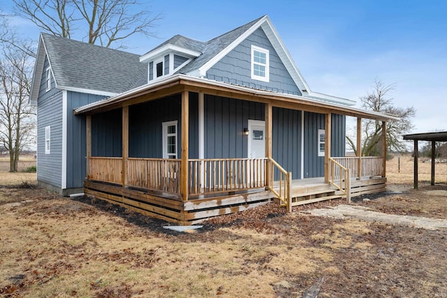 farmhouse with covered porch, a shingled roof, and board and batten siding