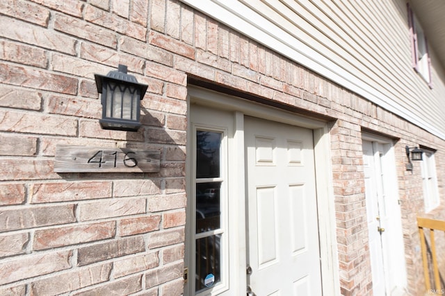 entrance to property featuring brick siding