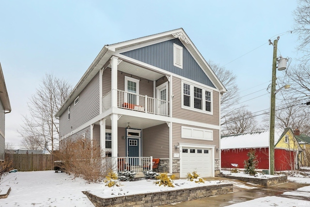 view of front of home featuring a balcony, an attached garage, fence, and a porch