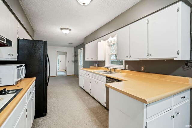 kitchen featuring white microwave, a sink, a textured ceiling, white cabinetry, and stainless steel dishwasher