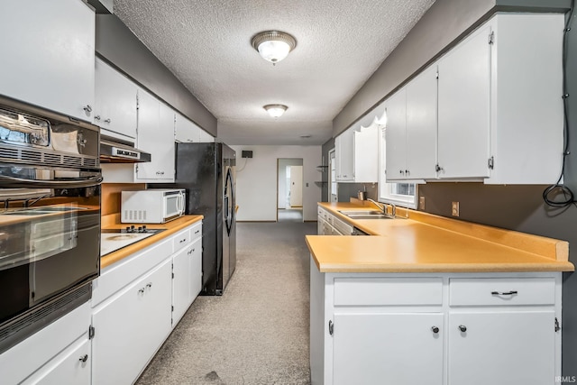 kitchen featuring white cabinets, a sink, a textured ceiling, under cabinet range hood, and black appliances