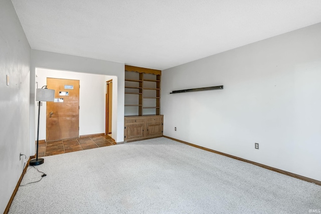 unfurnished room with carpet flooring and baseboards