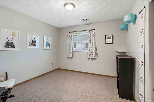 unfurnished office with baseboards, visible vents, and carpet flooring