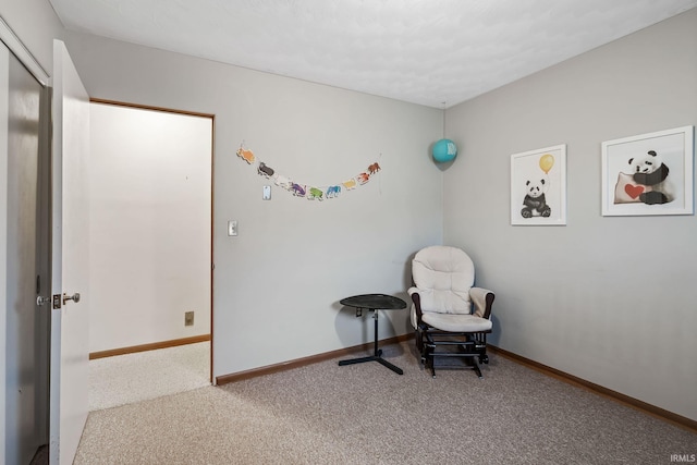 living area featuring carpet flooring and baseboards