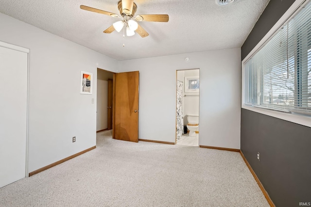 unfurnished bedroom with baseboards, a textured ceiling, and light colored carpet