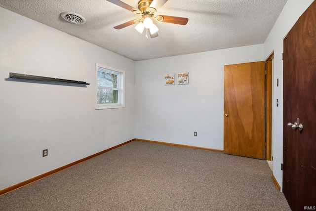 carpeted empty room with a textured ceiling, ceiling fan, visible vents, and baseboards