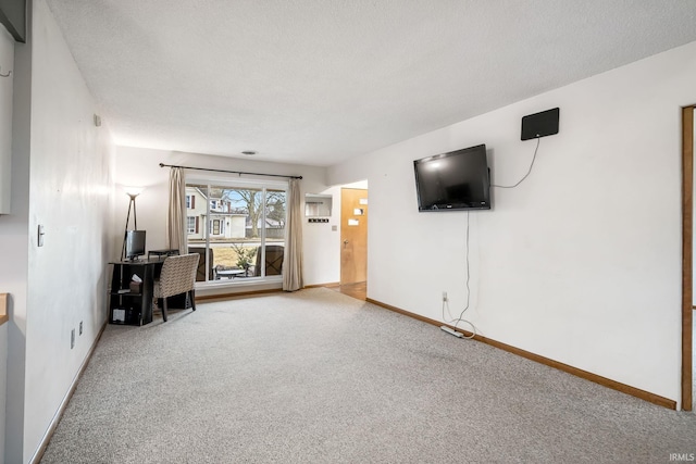 unfurnished office featuring carpet floors, a textured ceiling, and baseboards