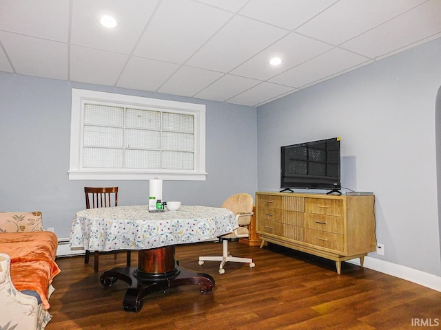 dining room with a paneled ceiling, baseboards, arched walkways, and wood finished floors