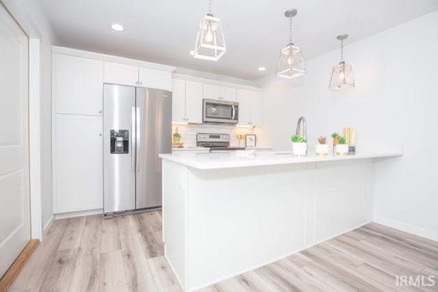 kitchen featuring light countertops, appliances with stainless steel finishes, light wood-style flooring, and white cabinetry