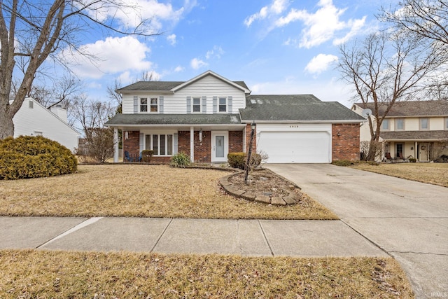 traditional-style house featuring brick siding, a shingled roof, concrete driveway, a front yard, and a garage