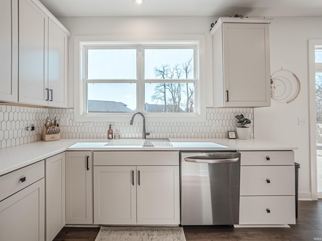 kitchen featuring a sink, white cabinetry, light countertops, dishwasher, and tasteful backsplash