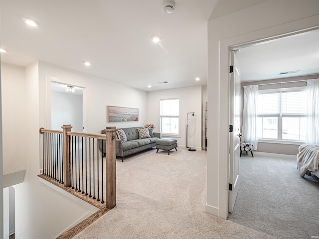 corridor featuring carpet floors, recessed lighting, baseboards, and an upstairs landing