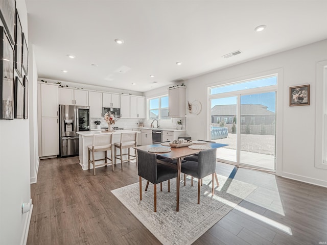 dining space featuring baseboards, wood finished floors, visible vents, and recessed lighting