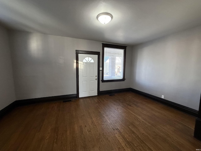 foyer featuring dark wood-type flooring and baseboards