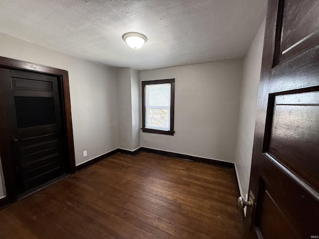 interior space with dark wood-style floors, baseboards, and a textured ceiling