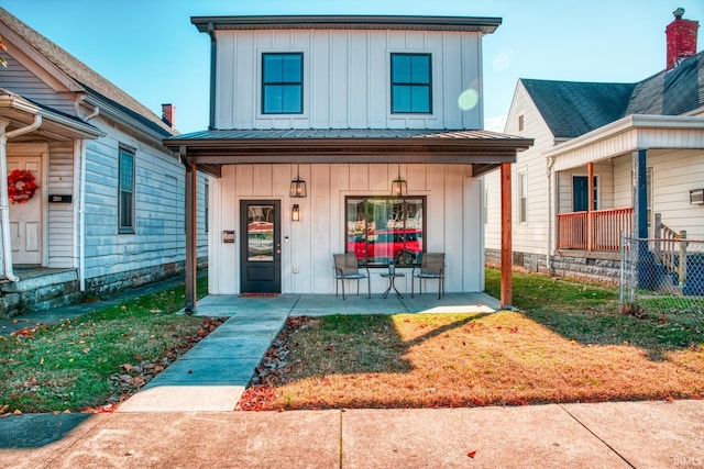 view of front of property with board and batten siding, covered porch, metal roof, and a standing seam roof