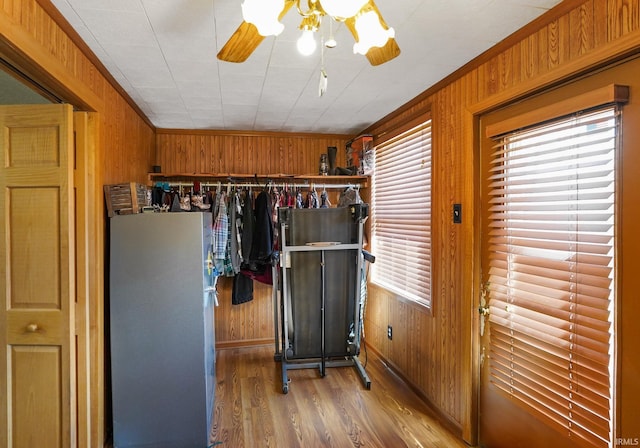 interior space featuring wood walls, crown molding, and wood finished floors