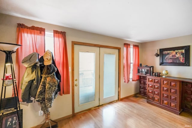 entryway with baseboards, wood finished floors, and french doors