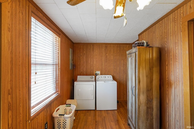 clothes washing area featuring laundry area, plenty of natural light, washer and dryer, and wood finished floors