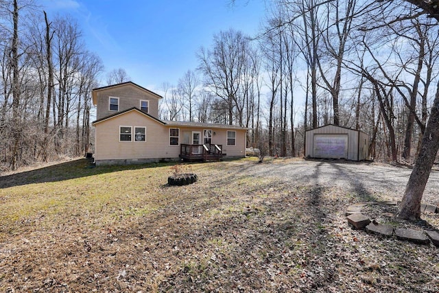 view of front facade featuring a front lawn, an outdoor structure, driveway, and a detached garage