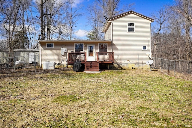 rear view of property with a fenced backyard, a lawn, and a wooden deck