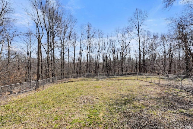 view of yard featuring fence and a wooded view