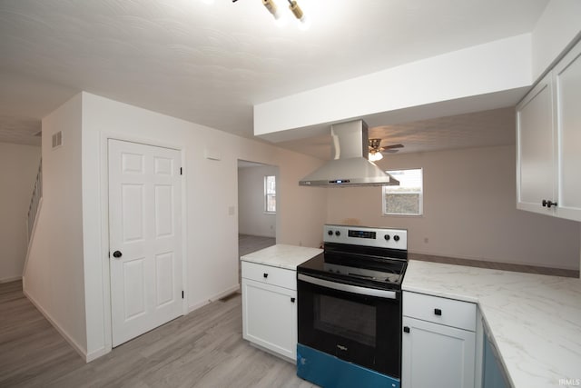 kitchen featuring light stone counters, range with electric cooktop, visible vents, light wood-style floors, and wall chimney range hood