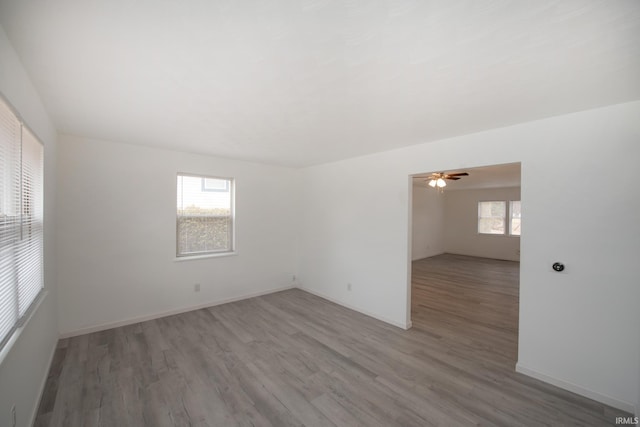 spare room with ceiling fan, baseboards, and wood finished floors