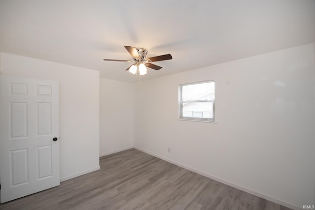 unfurnished room with baseboards, ceiling fan, and light wood-style floors