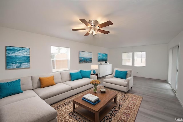 living area with a ceiling fan and light wood-type flooring