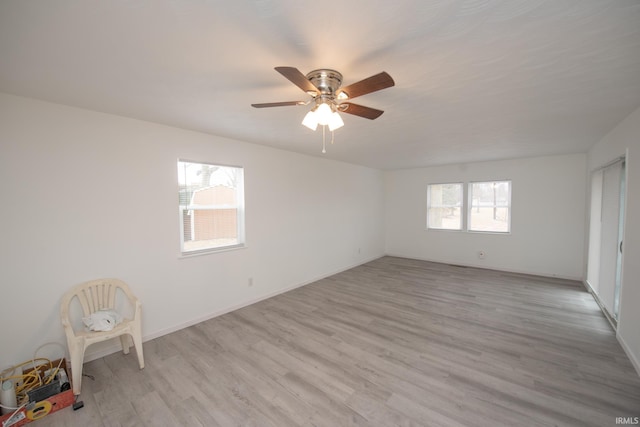 unfurnished room featuring light wood-style flooring, baseboards, and a ceiling fan