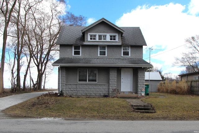 traditional style home with a front lawn and a shingled roof