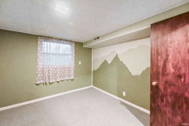 spare room with carpet flooring, visible vents, and baseboards