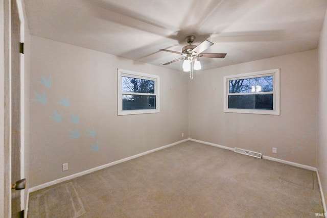 empty room featuring carpet, visible vents, ceiling fan, and baseboards